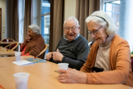 photo montrant un homme et une femme âgés, joyeux, attablées et jouant au lotto