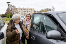 photo montrant une aide à domicile aidant une personne âgée à montrer dans sa voiture